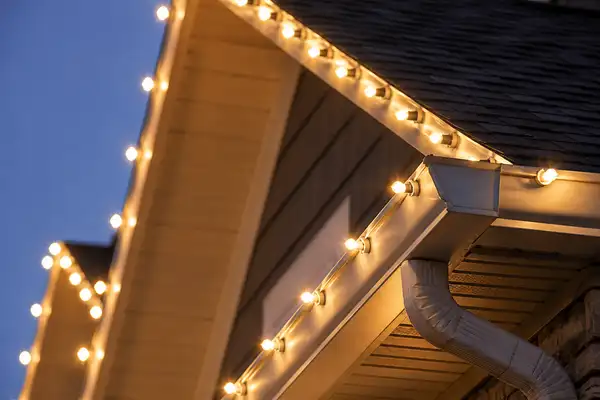Professional holiday light installation detail on roof and gutters