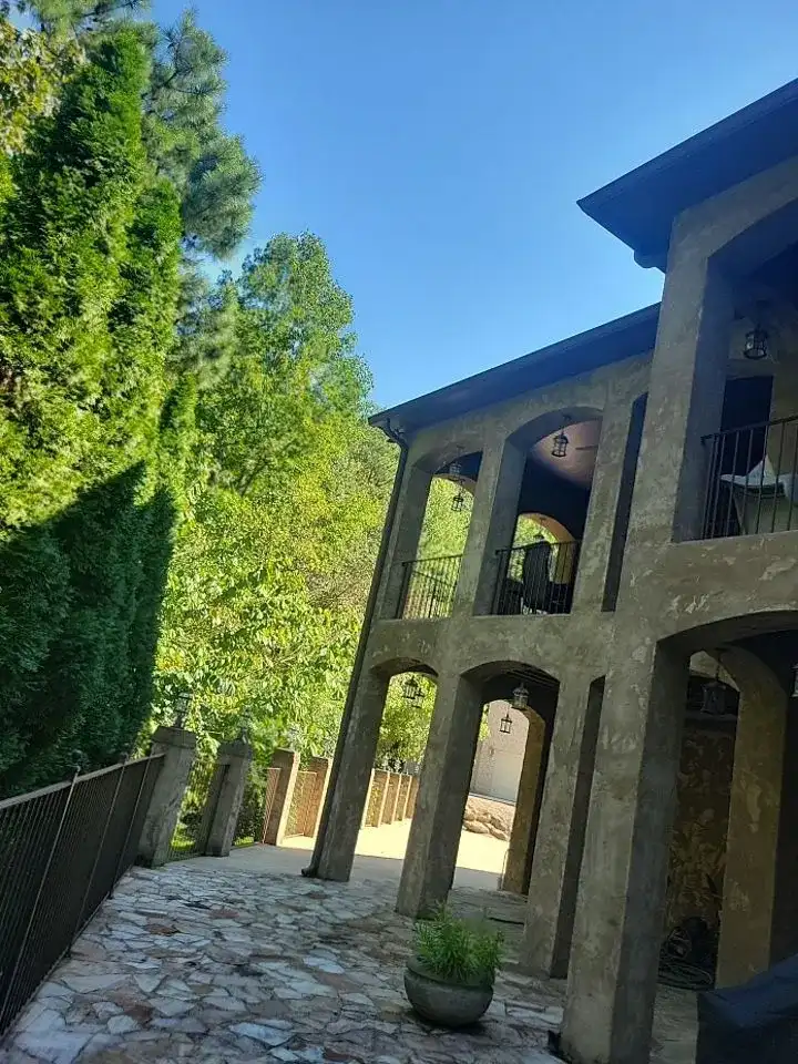 A large stone building with a stone walkway and a stone balcony.