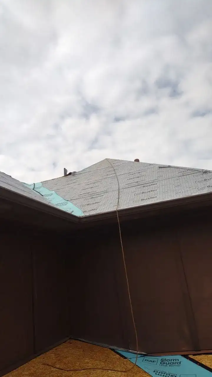 A roof under construction with a blue tarp covering it.