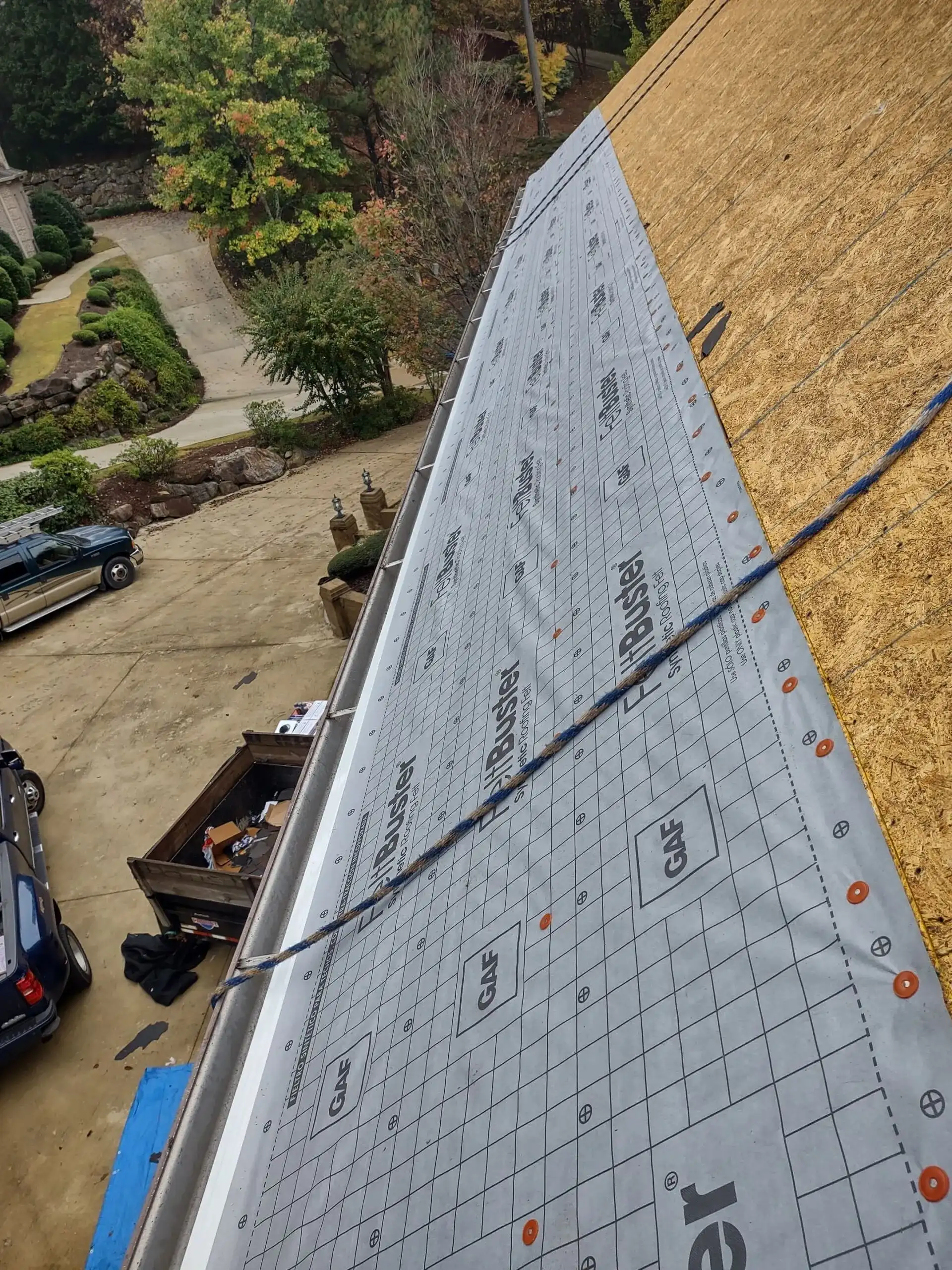 A roofing project in progress with a blue tarp covering the roof.
