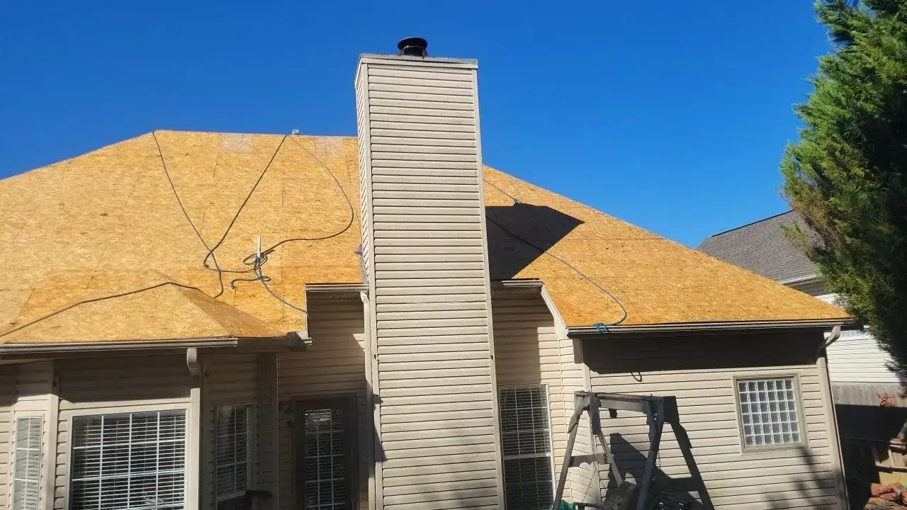 A white chimney on a house with a blue sky in the background.