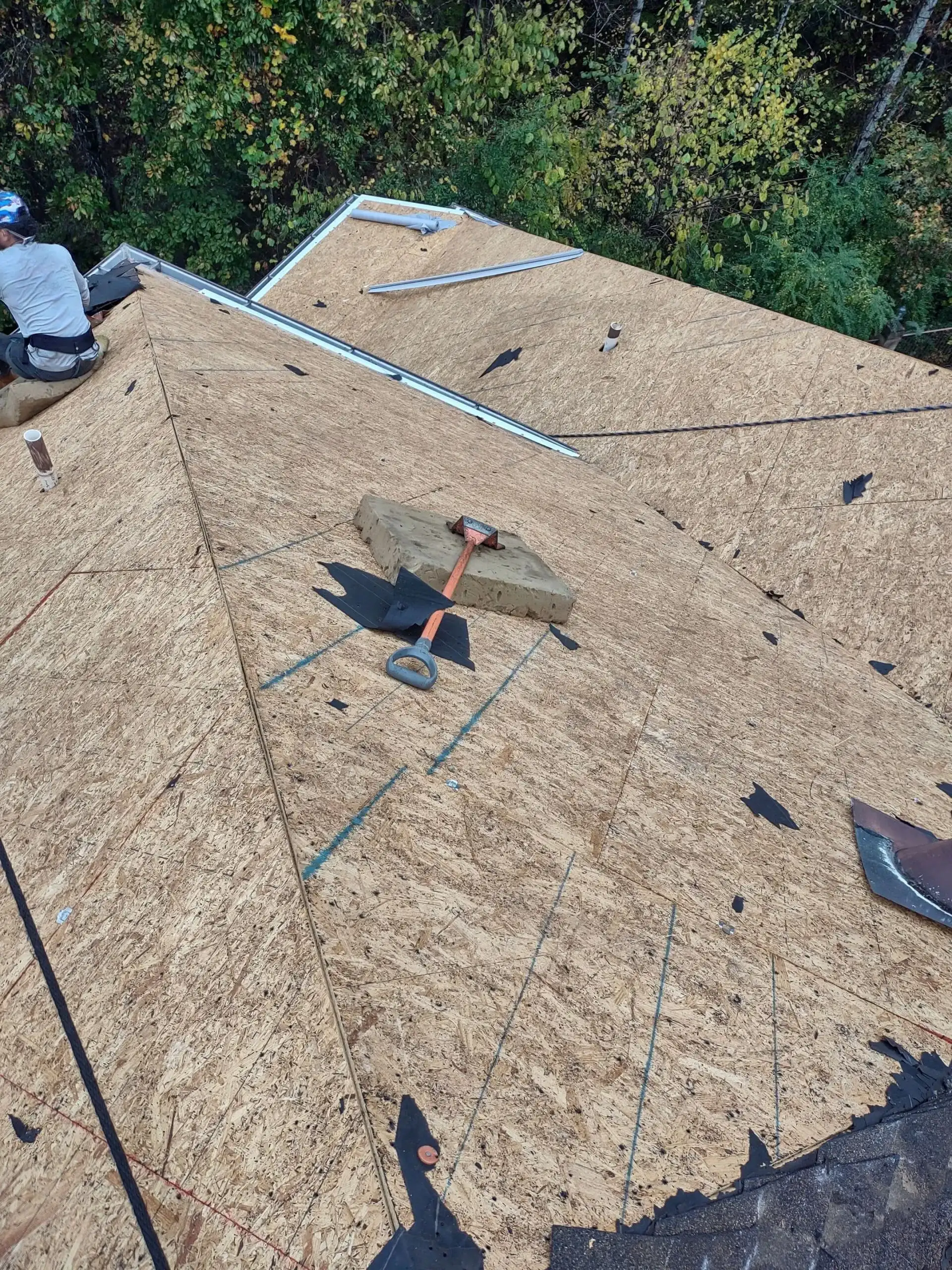 A man working on a roof with a hammer.