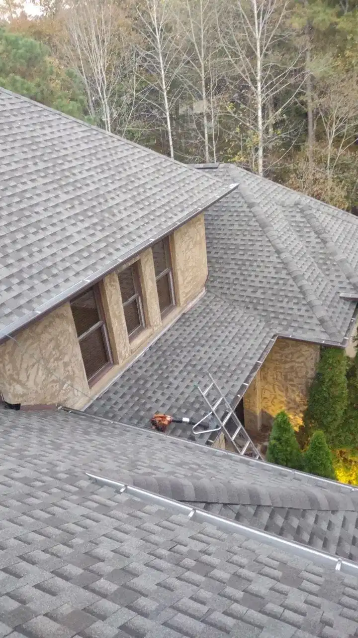 A man working on a roof in a residential area.